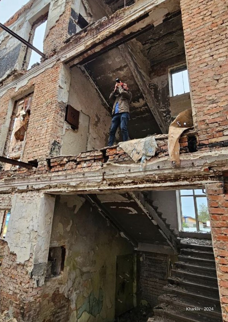 Cyrus Atory photographiant dans un bâtiment bombardé, Kharkiv 2024